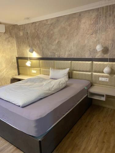 a bed in a room with two lights above it at Das kleine Landhotel in Dorsten