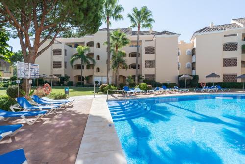 マルベーリャにあるHacienda Playaのホテル正面のスイミングプール(ラウンジチェア付)