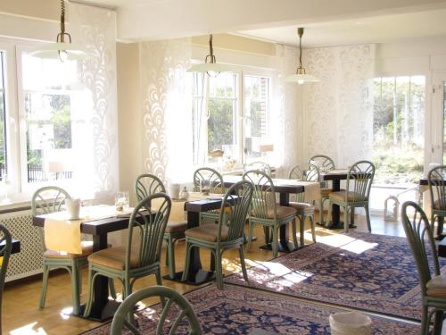 a dining room with tables and chairs and windows at Strandhotel-Najade in Borkum