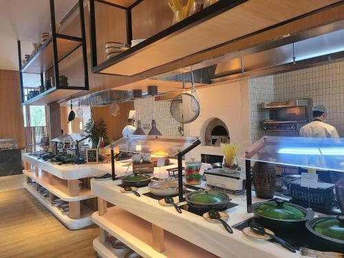 a kitchen with people working in a kitchen at Novotel Hyderabad Airport in Hyderabad