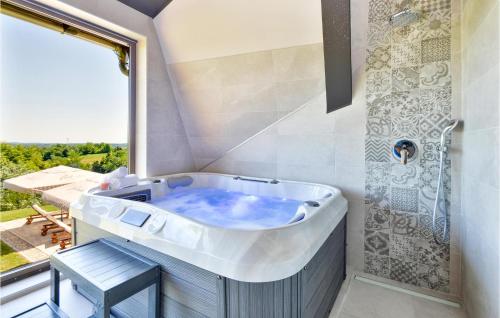 a bath tub in a bathroom with a window at Lovely Home In Bedenica With Heated Swimming Pool in Bedenica