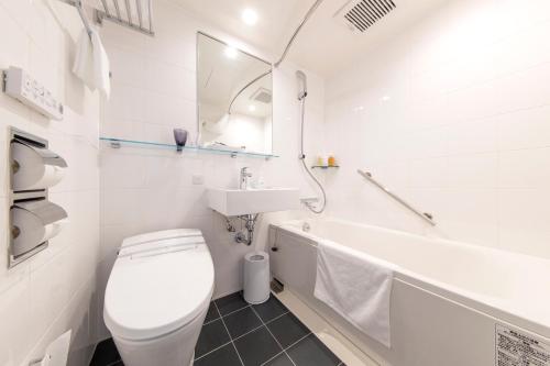 a white bathroom with a toilet and a sink at Hotel Forza Nagoya Sakae in Nagoya