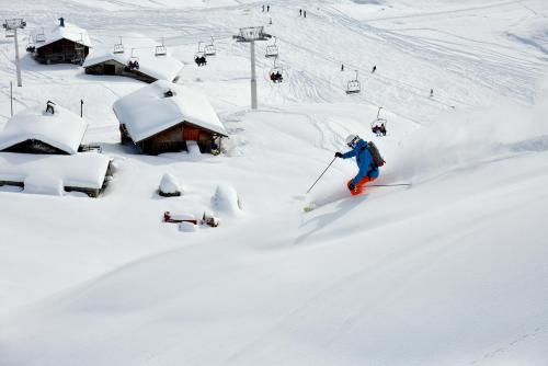 a person is skiing down a snow covered slope at Studio Forclaz in Le Grand-Bornand