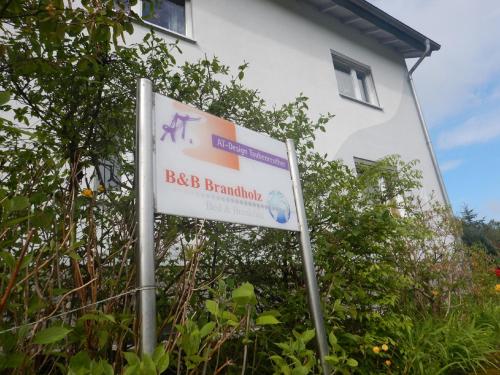 a sign in front of a white building at B&B Brandholz in Goldkronach