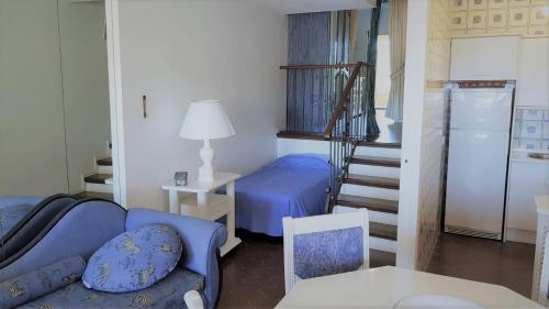 a living room with a blue couch and a staircase at K105 Cabopino in Marbella
