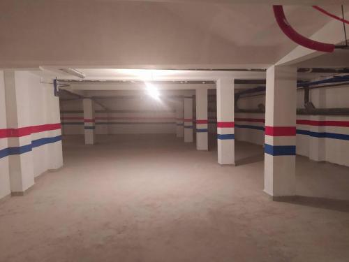 an empty parking garage with red white and blue stripes at Appartement Hamria Meknes in Meknès