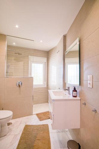 a bathroom with a sink and a toilet and a mirror at L166 Cabopino in Marbella