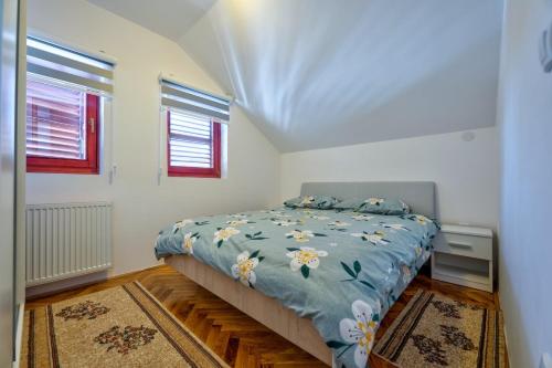 a bedroom with a bed with a blue comforter at Vila Nikola Zlatibor in Zlatibor