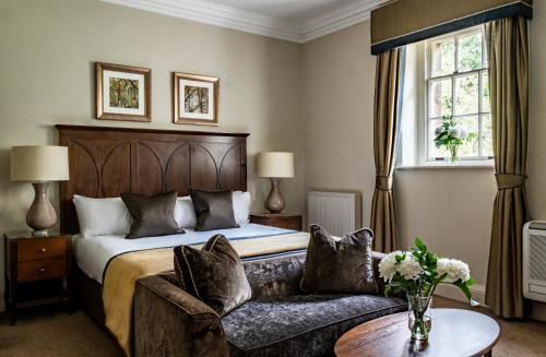 um quarto de hotel com uma cama e um sofá em Crathorne Hall em Yarm