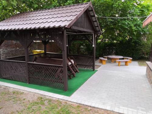 - un kiosque en bois avec des bancs et des tables de pique-nique dans l'établissement Kupa Villa, à Balatonboglár