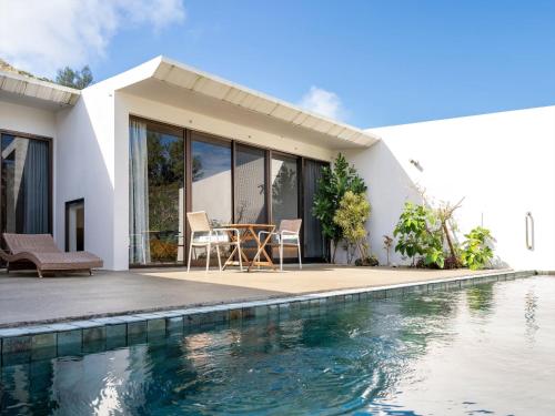 a house with a swimming pool next to a house at The Rescape in Miyako-jima