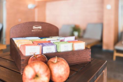 two apples sitting on top of a table with books at Felbermayer Hotel & AlpineSpa-Montafon in Gaschurn