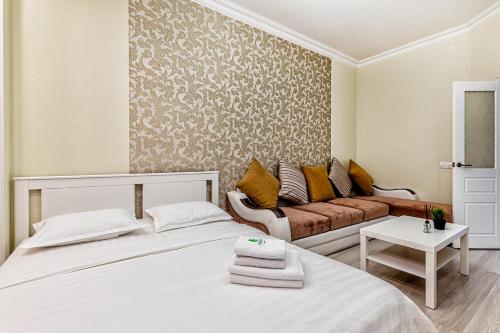 sala de estar con 2 camas y sofá en Raisson Ahotel F107, en Astana
