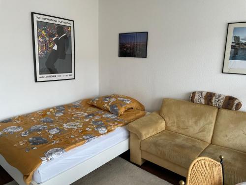 a bed and a couch in a room at wohnliches , behagliches Zimmer mit Balkon und wifi in Mönchengladbach