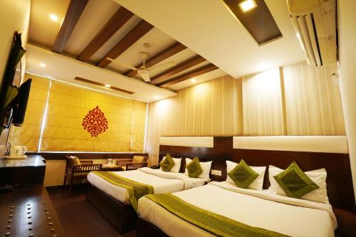 a hotel room with two beds and a desk at Hotel Dreamland Chandigarh in Chandīgarh