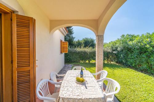 einen Tisch und Stühle auf einer Terrasse mit einem Torbogen in der Unterkunft ISS Travel, L'Avru - 700 m from La Cinta beach in San Teodoro