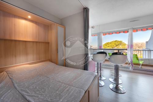ein Schlafzimmer mit einem Bett und einem großen Fenster in der Unterkunft AS9557 - Studio vue sur la mer avec parking privé proche centre ville in Le Grau-du-Roi
