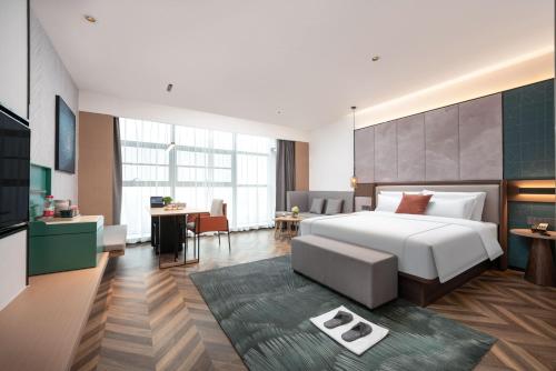 um quarto com uma grande cama branca e uma secretária em 银座佳悦精选酒店冠县冠宜春路店 em Kwanhsien