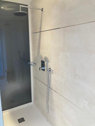 a shower with a shower head in a bathroom at Appart' Au Coeur de Nuits in Nuits-Saint-Georges