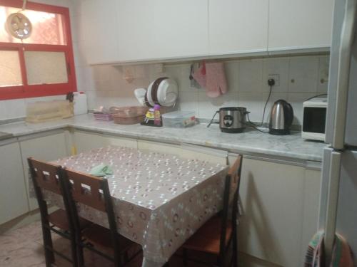 una pequeña cocina con mesa y encimera en Furnished room just 1 minute to Al ain mall, en Al Ain