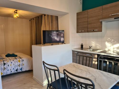 une cuisine avec une table et des chaises dans une pièce dans l'établissement STUDIO BARBUSSE, à Agen