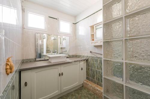 uma casa de banho com um lavatório e um espelho em AS19003- P4 à 400m de la plage avec garage 2 voitures em Le Grau-du-Roi
