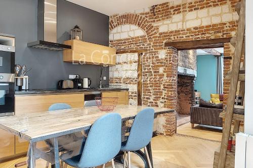 une cuisine et une salle à manger avec une table et des chaises bleues dans l'établissement AA13 - Le Victor HUGO - séjour d’exception dans un appartement historique, à Ault