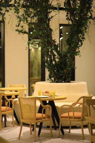 a table and chairs in a room with plants at Aitch Boutique Hotel - an LIH Hotel in Madaba