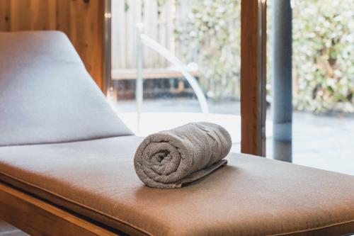 un asciugamano arrotolato, poggiato sopra un letto di Felbermayer´s Bed & Breakfast a Gaschurn