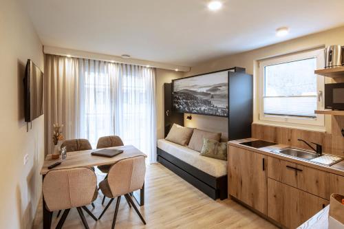 eine Küche und ein Wohnzimmer mit einem Tisch und einem Sofa in der Unterkunft Forellenhof Rössle Hotel & Restaurant in Honau