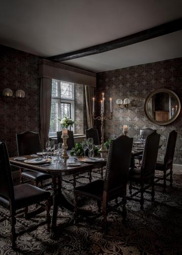 a dining room with a table and chairs and a mirror at New Hall Hotel & Spa, Birmingham in Birmingham