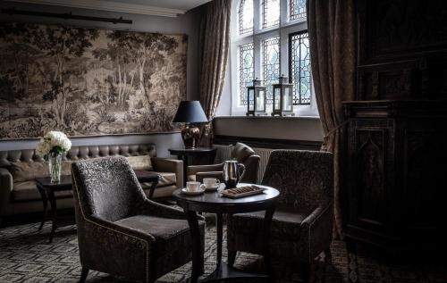 a living room with a couch and a table and chairs at New Hall Hotel & Spa, Birmingham in Birmingham