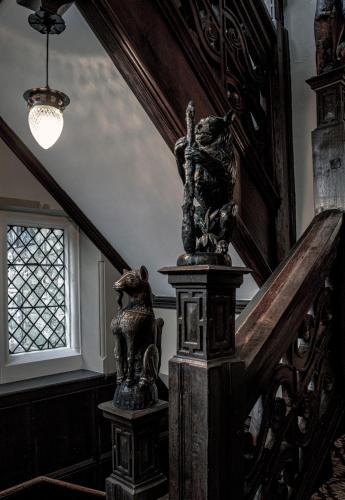 a stairway with a statue on a column in a house at New Hall Hotel & Spa, Birmingham in Birmingham