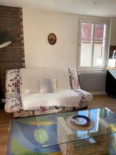 a living room with a couch and a glass table at Le Cosy in Schiltigheim