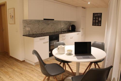 a kitchen with a table with a laptop on it at Mountain Oasis Apartment Kandersteg-Adelboden in Kandergrund