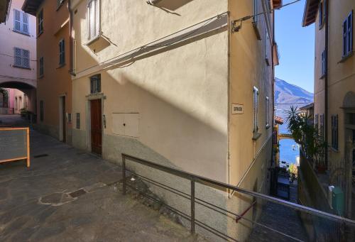 a building with a railing next to a street at Casa di Mezzo "Historic centre of VARENNA" Lake Como in Varenna