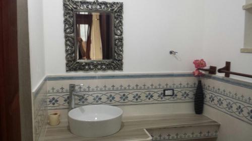 La salle de bains est pourvue d'un lavabo et d'un miroir mural. dans l'établissement Ianira - Le due Lune, à Lampedusa