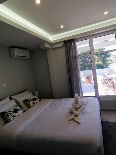 a bedroom with a large bed with a large window at Casa para ti in Porto Heli