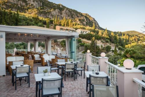 
a patio area with tables, chairs, and tables at Odysseus Hotel in Paleokastritsa
