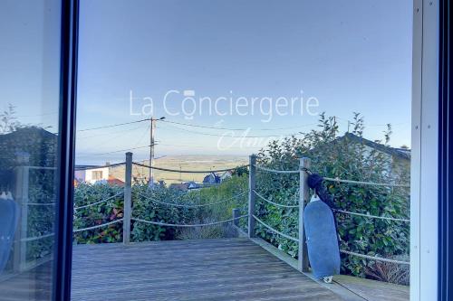 a glass door with a view of a wooden bridge at AJ 09 - Villa "Le Hublot" in Ault