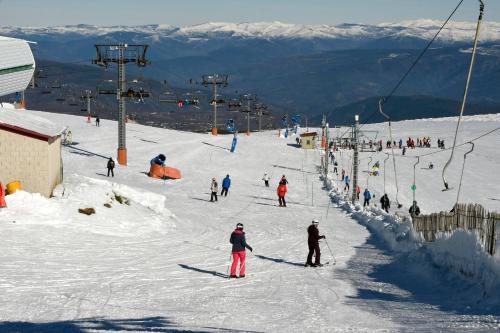 a group of people skiing down a ski slope at Estación de Montaña Manzaneda in Puebla de Trives