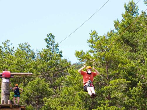 a man jumping in the air on a zip line at Estación de Montaña Manzaneda in Puebla de Trives