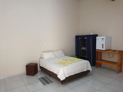a bedroom with a bed and a table and a desk at Pousada & Pesca Esportiva Fazolin in Socorro