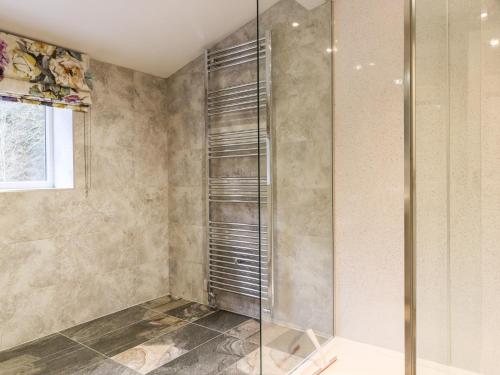 a shower with a glass door in a bathroom at Paradise Cottage in Harrogate