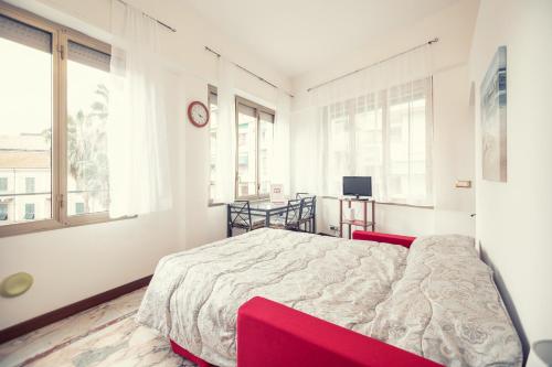 a bedroom with a bed in a room with windows at Sanremo City Center II by Wonderful Italy in Sanremo