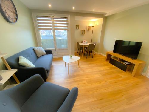 een woonkamer met een bank, een tv en een tafel bij Appartement renove et moderne L'Eustache in Calais