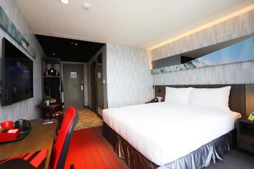 a hotel room with a large bed and a desk and a desk at T11、T12 Hotel in Houli