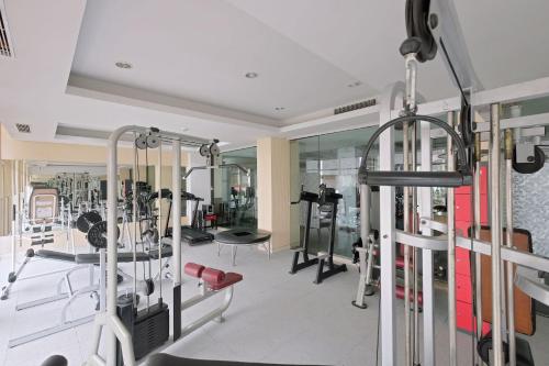 a gym with several treadmills and machines at Metro Park View Hotel Kota Lama Semarang in Semarang