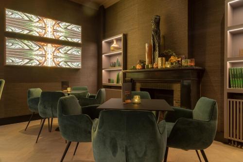 a dining room table with chairs and a television at Hotel Montanus in Bruges