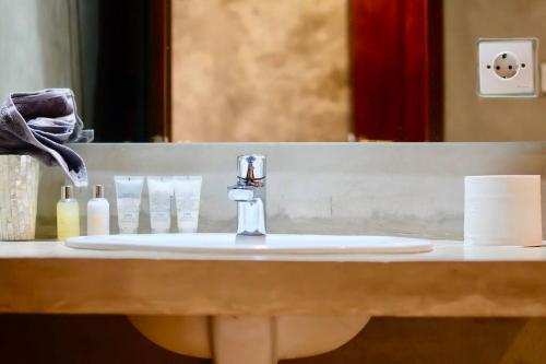 un lavandino del bagno con un rubinetto davanti a uno specchio di Villa Cleopatra Bali a Sanur